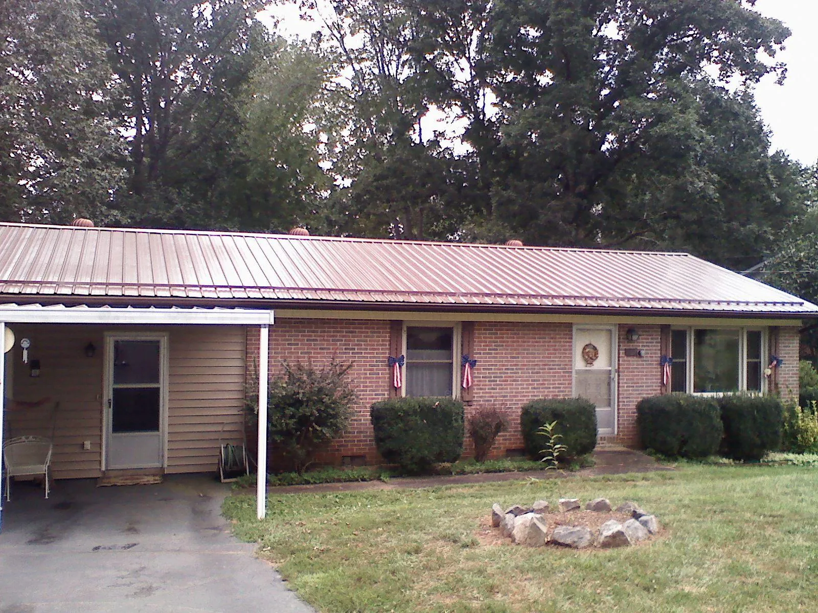 Bronze metal roof and carport on a brick ranch home — Roof Repair work by our crew in Bonita Springs