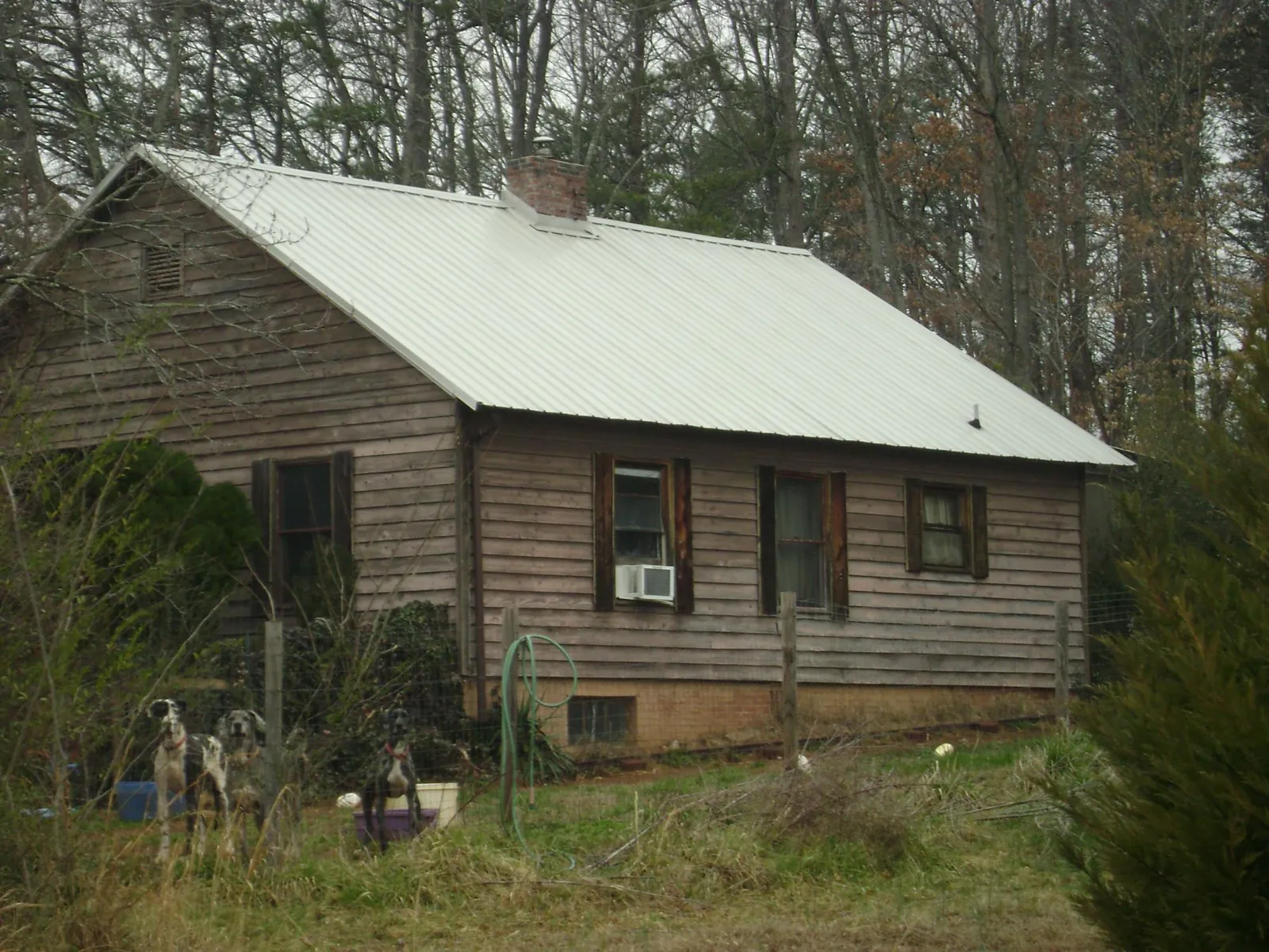 White metal roof on an old wood sided farmhouse, from a Metal Roof Installation job in Bonita Springs